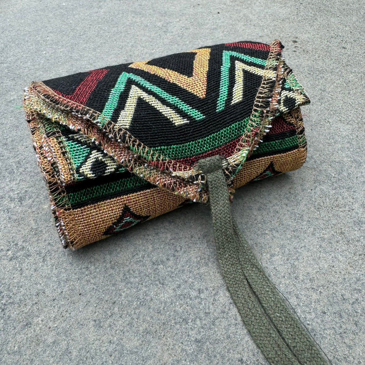 Green Aztec cotton leg wraps for LARP, rolled with visible ties.