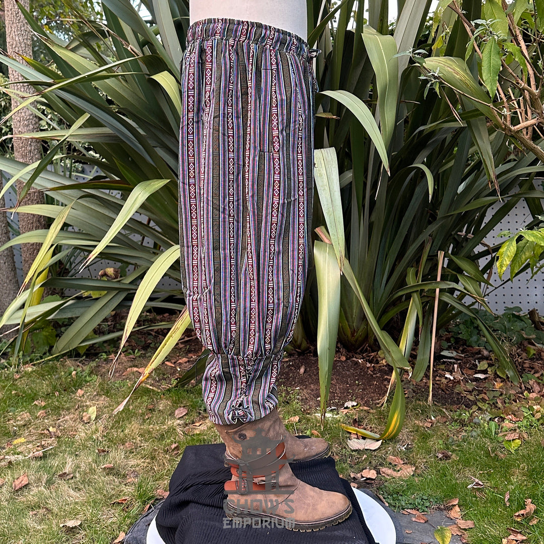 Side view of green cotton Viking-style pants with cord tie and ankle gathers.