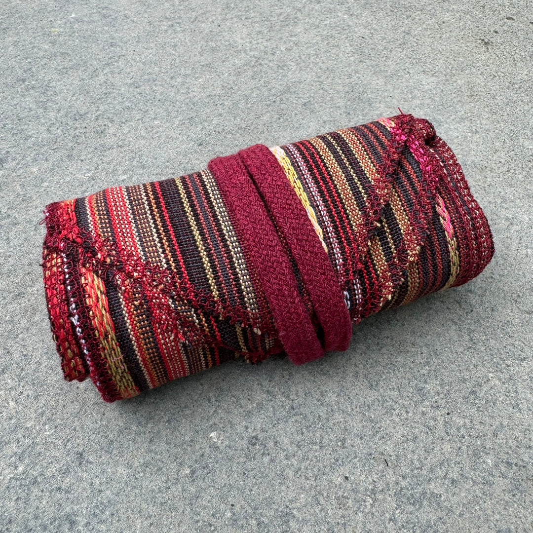Red striped cotton leg wraps rolled up for LARP.