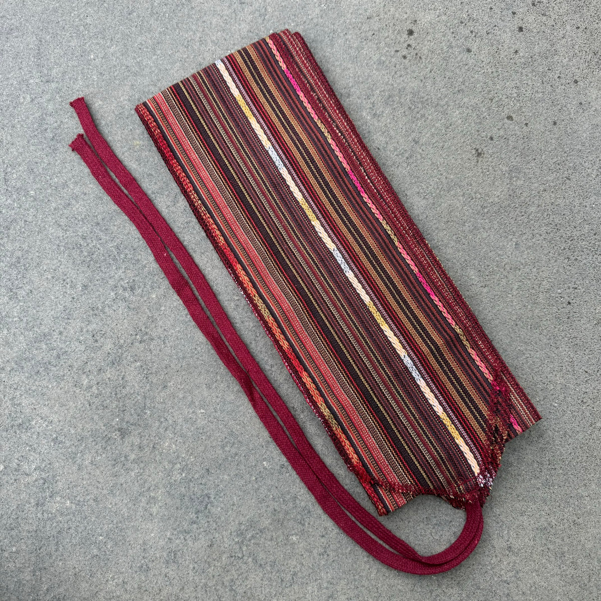 Red striped cotton leg wraps on a flat surface for LARP.