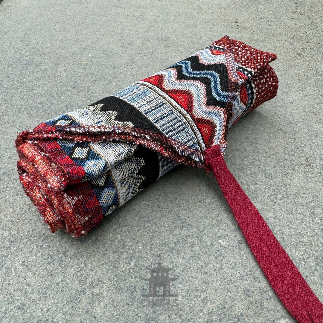 Nordic zigzag pattern pirate sash rolled, rich reds, blues, medieval LARP style.