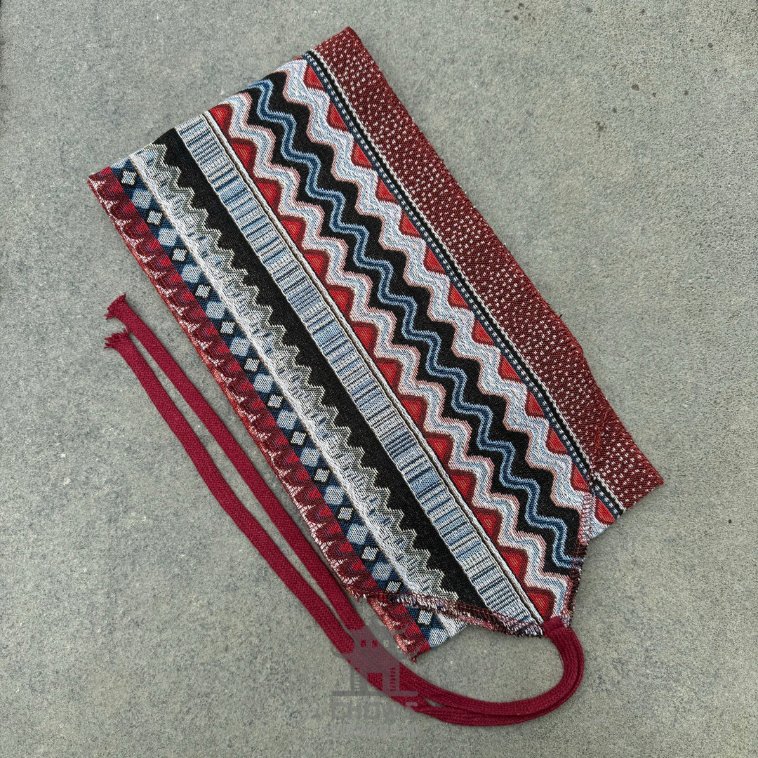 Red and blue zigzag medieval LARP sash on a grey surface.