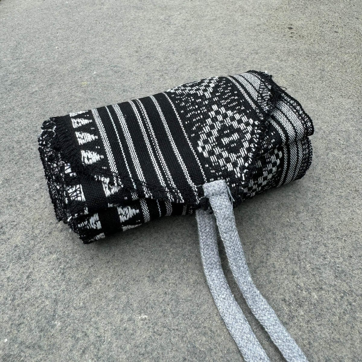 Black and white woven pirate sash rolled up for LARP.