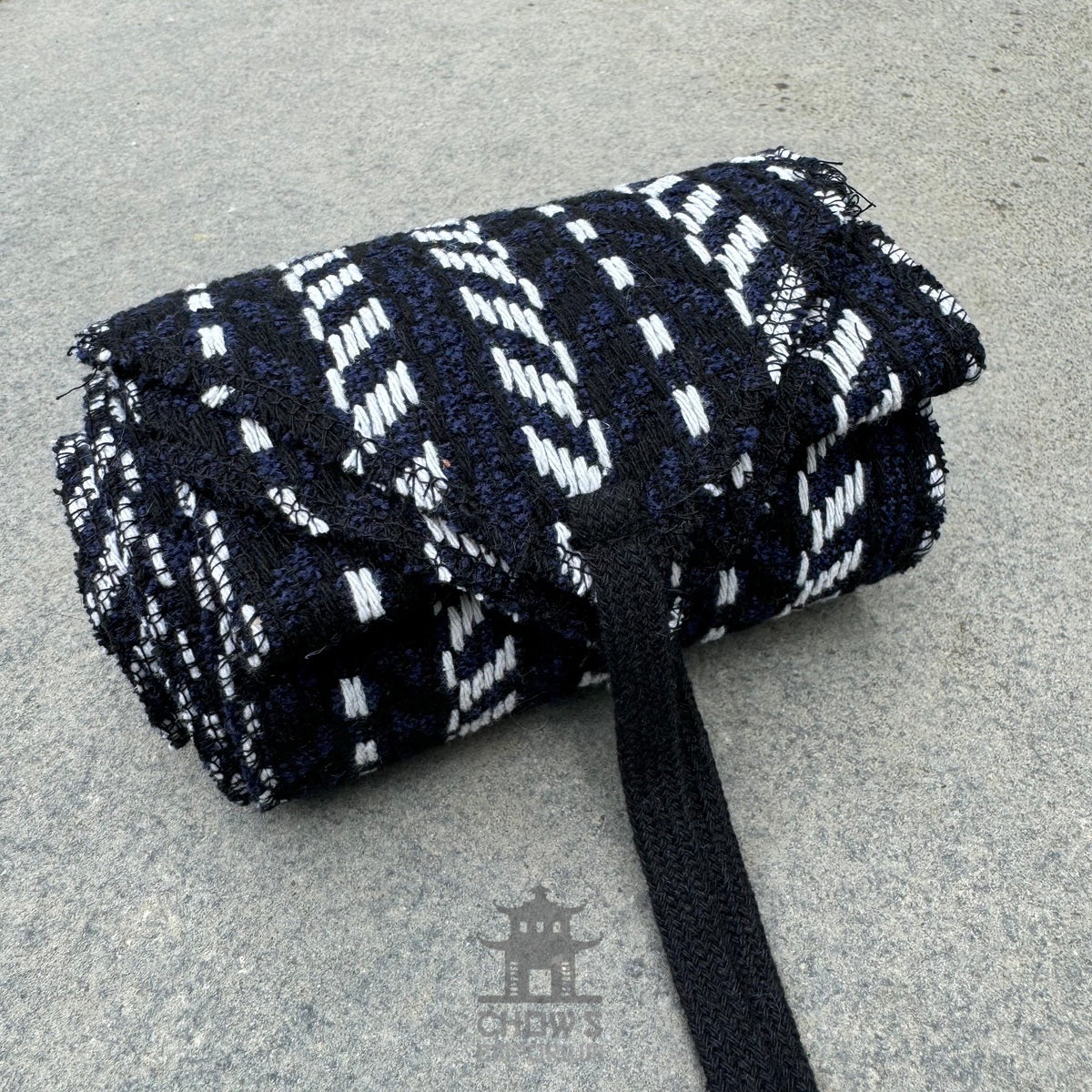 Black, white, and blue herringbone sash for LARP, rolled.