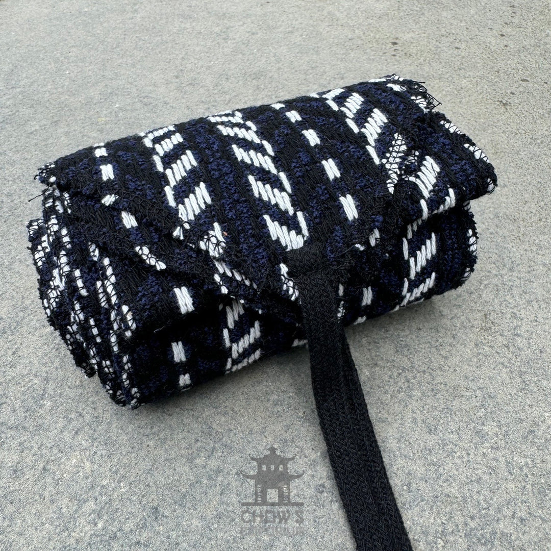 Black, white, and blue herringbone sash for LARP, rolled.