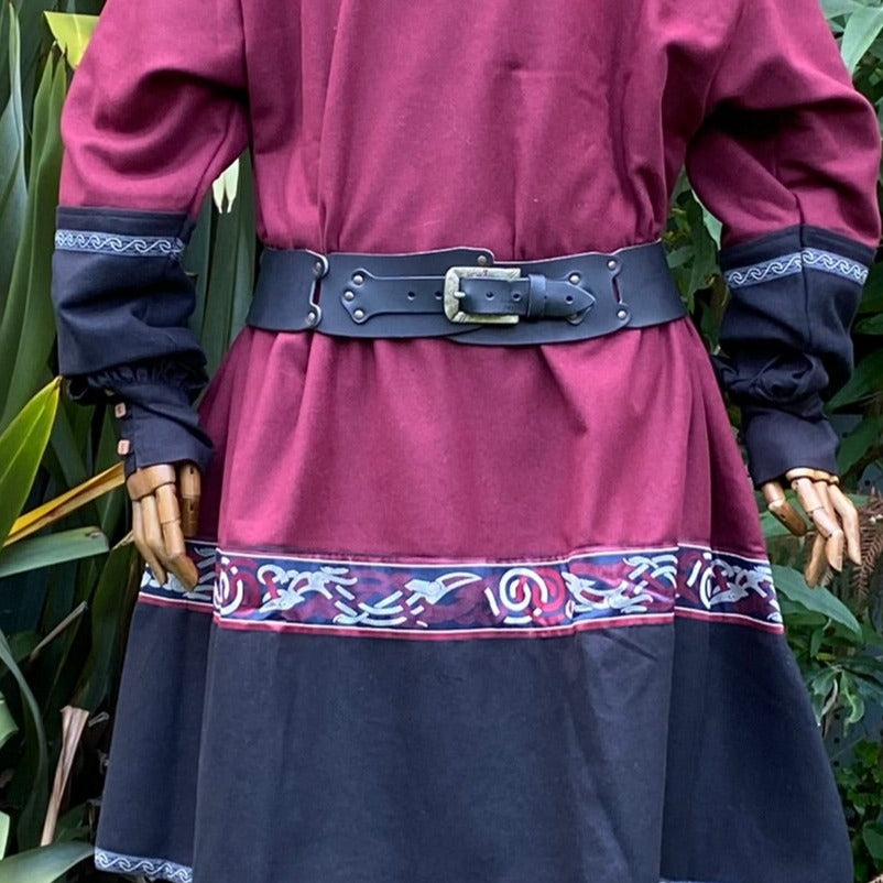 Back view of medieval LARP tunic with patterned trim and black belt.