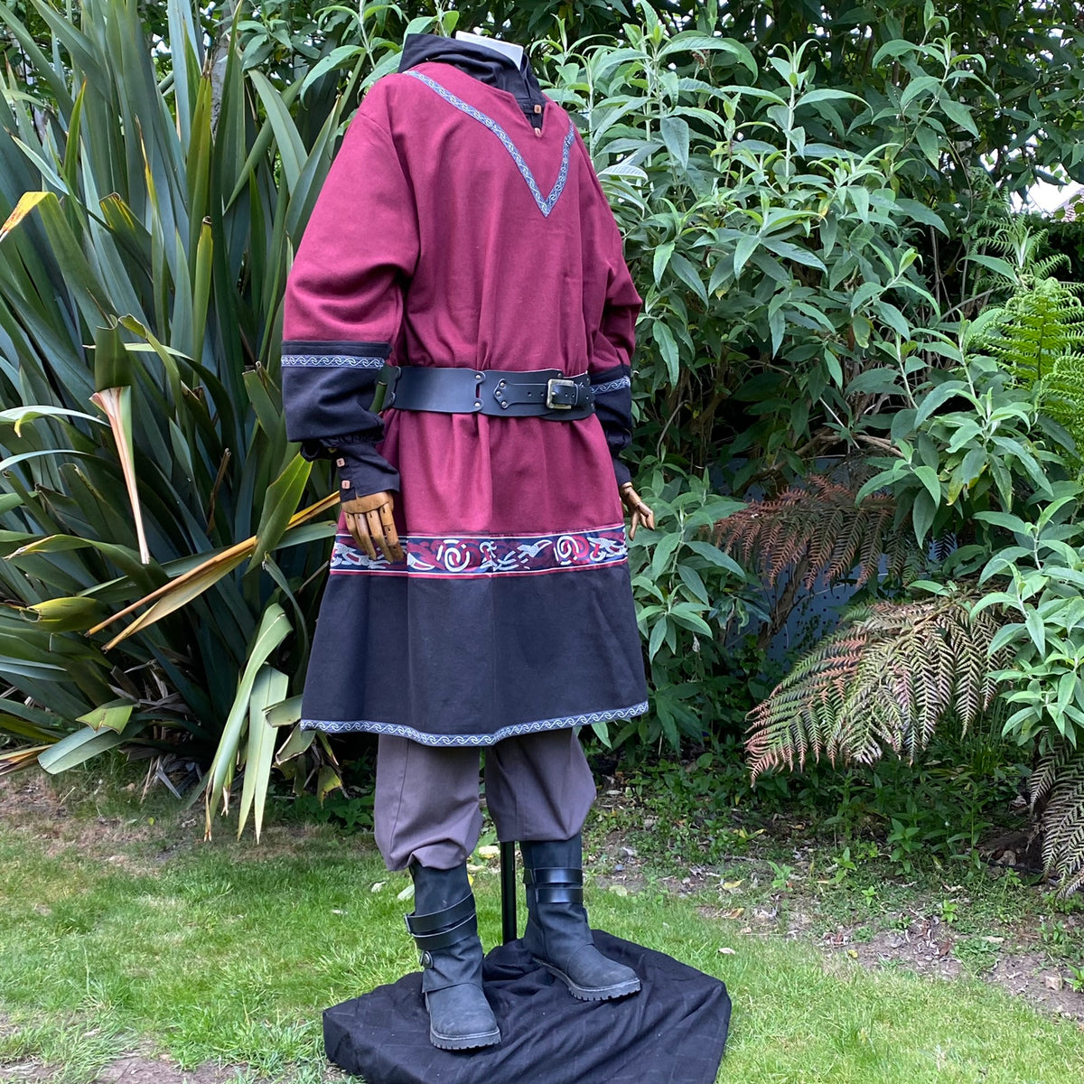 Side view of a red-black LARP Viking tunic, detailed trim and belt.