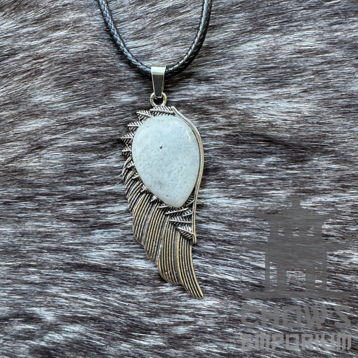 Silver feather necklace with stone pendant on textured fur background. LARP accessory.