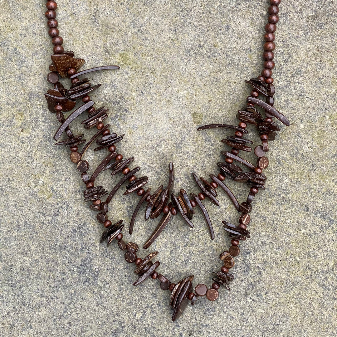 Brown rustic bead necklace, close-up on stone background, LARP accessory.