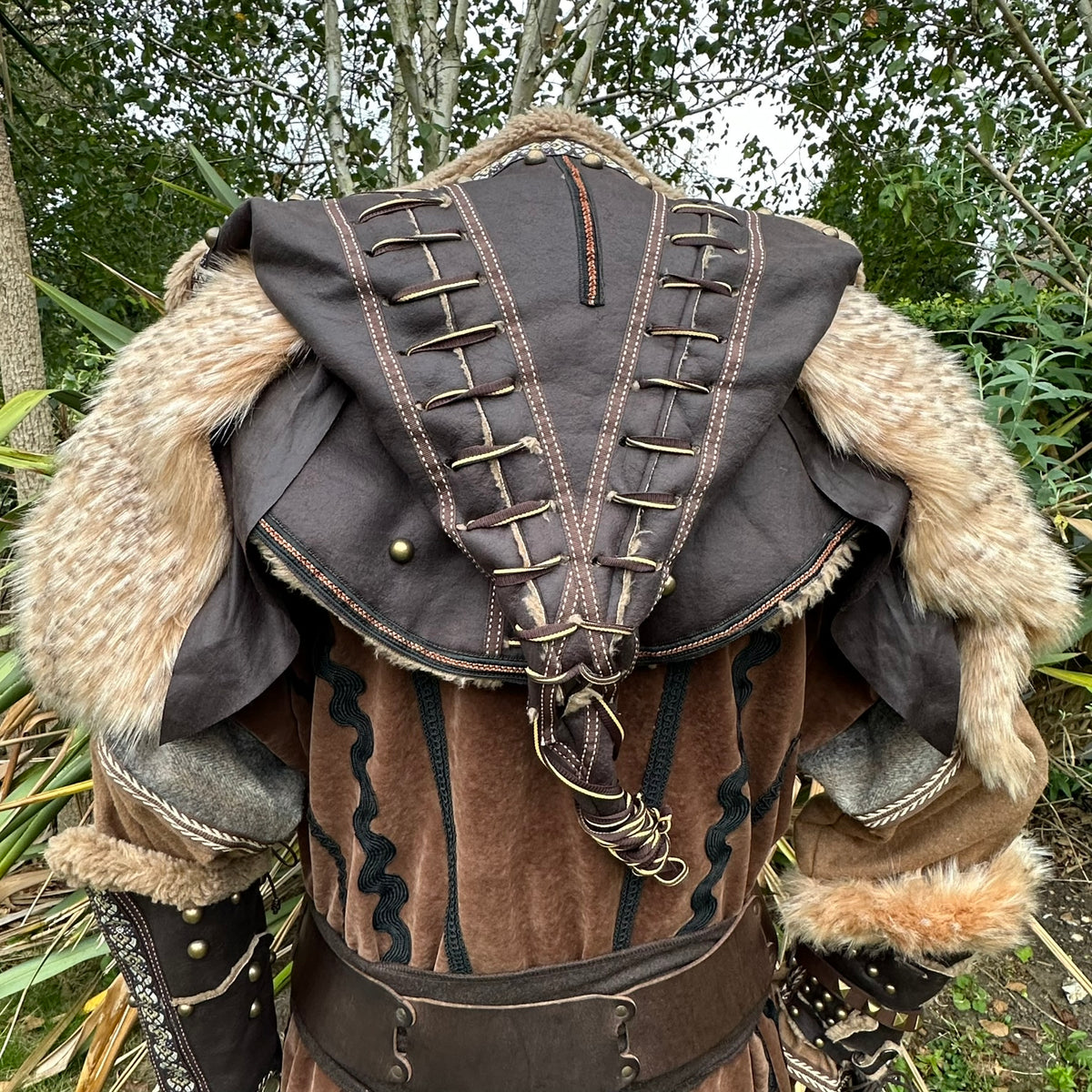 Back view of LARP costume; brown hood with lacing and fur accents.