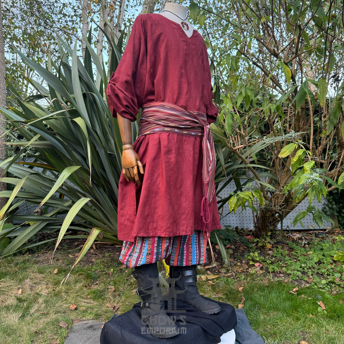 LARP red tunic with striped sash and pants, side view.