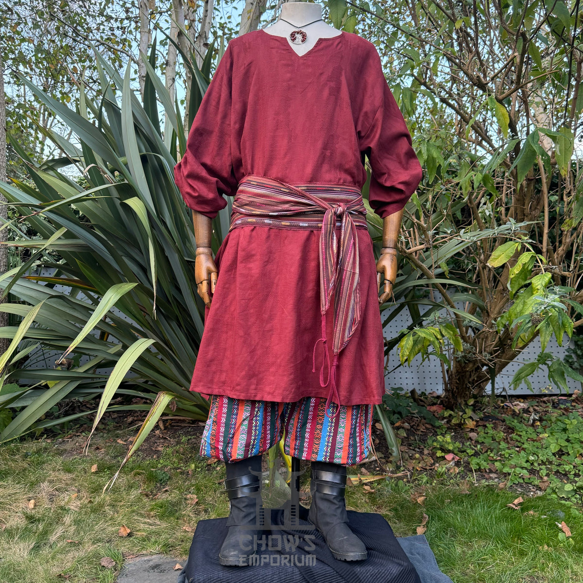 LARP medieval red tunic, striped pants, and sash on mannequin.