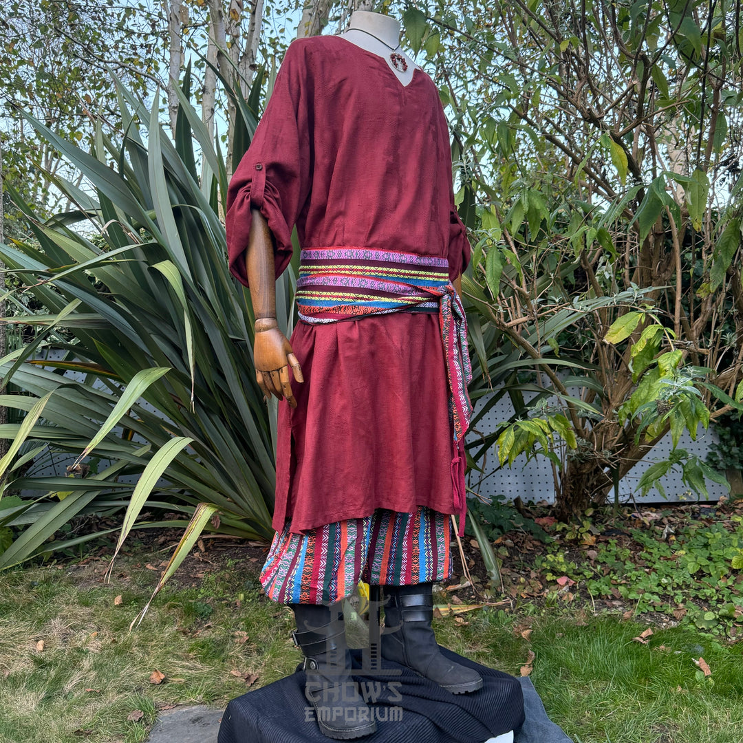 Red textured cotton medieval tunic for LARP, side view with striped belt.