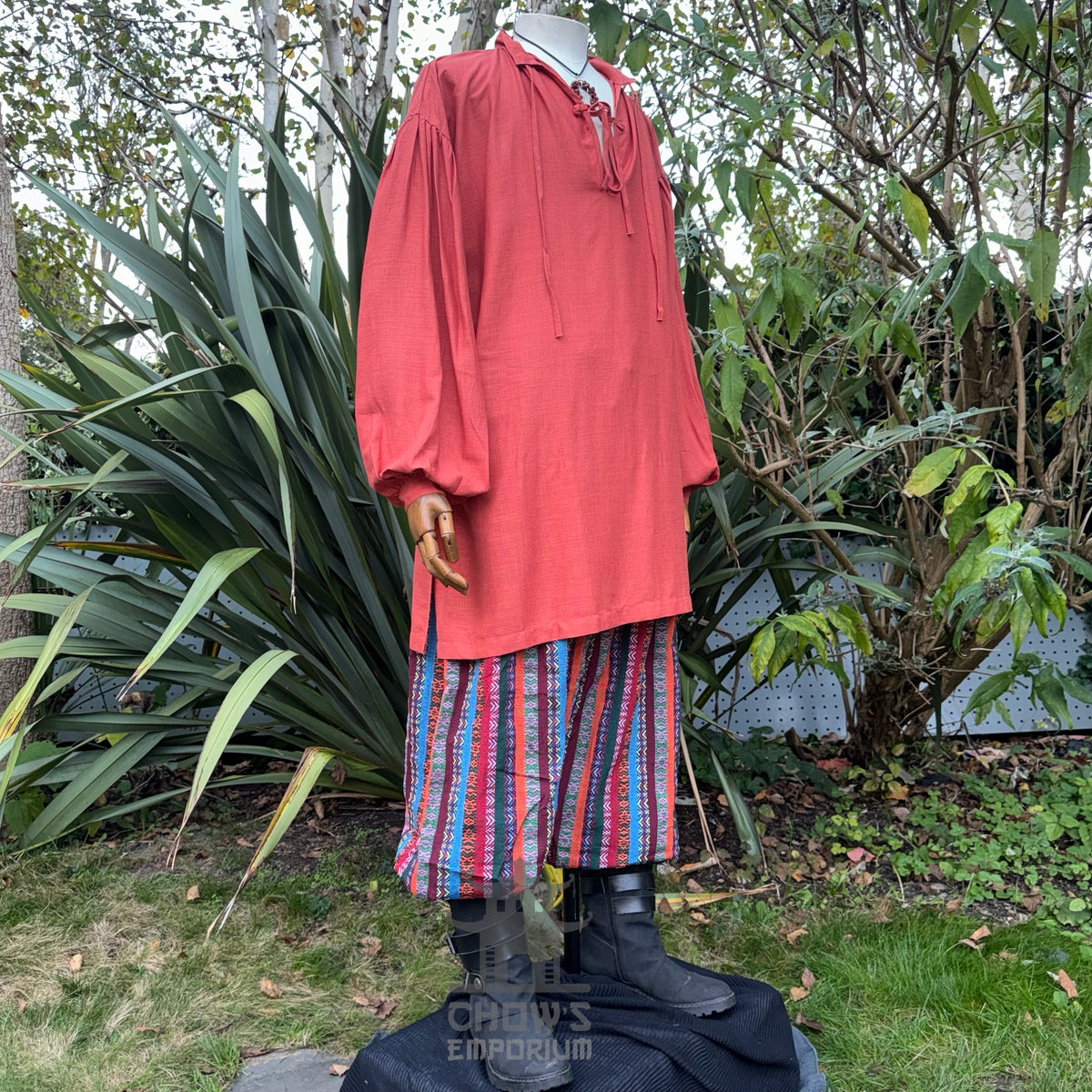 LARP medieval orange shirt, striped pants, sash on mannequin.