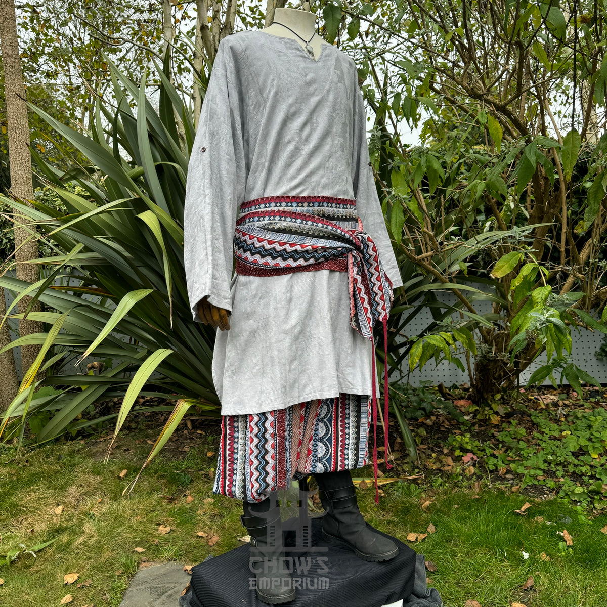 LARP medieval outfit, light grey tunic, colorful sash and trousers.