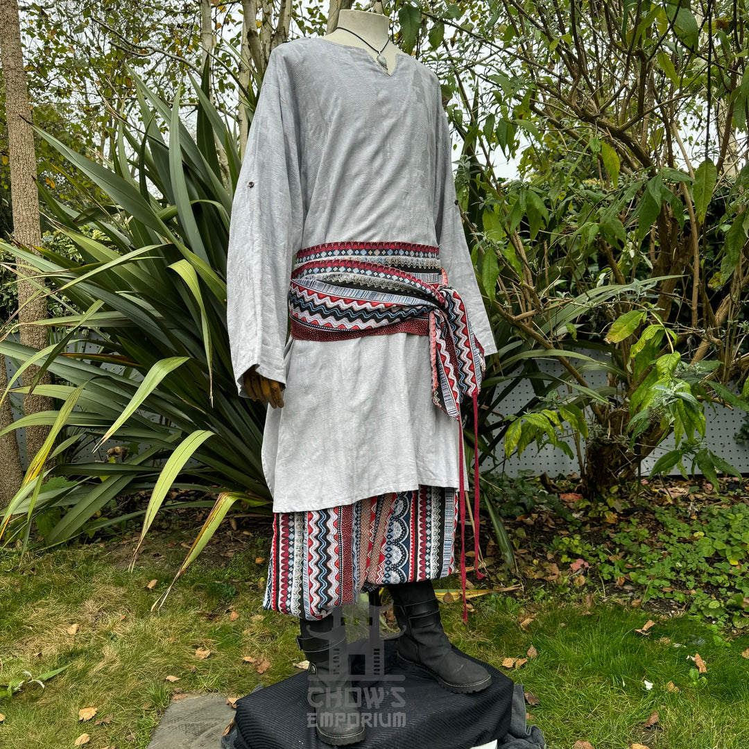 LARP medieval outfit, light grey tunic, colorful sash and trousers.