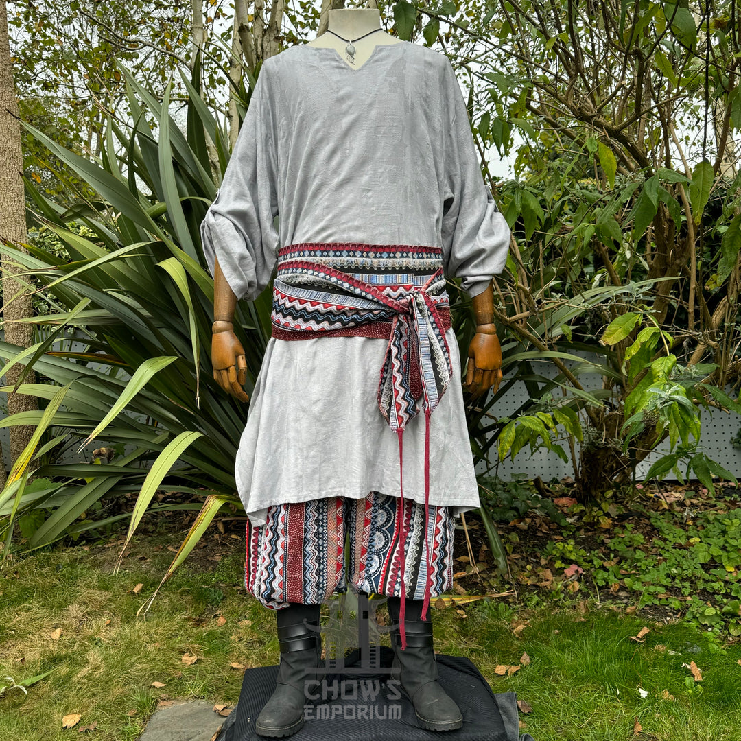Medieval LARP outfit front view, featuring a grey tunic, multi-striped trousers and matching sash.