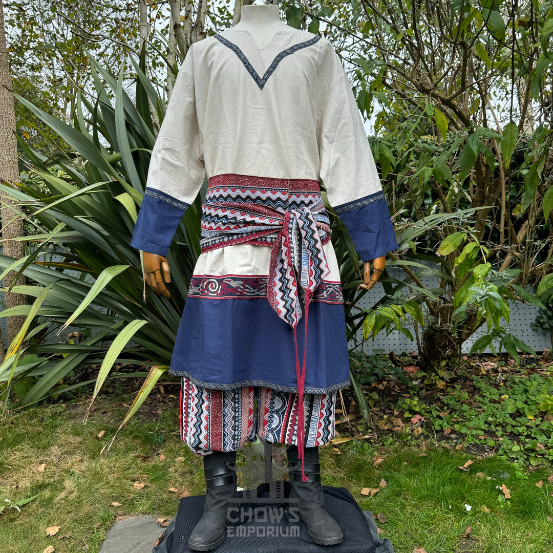 Rear view of medieval LARP outfit with blue sleeves and patterned sash.