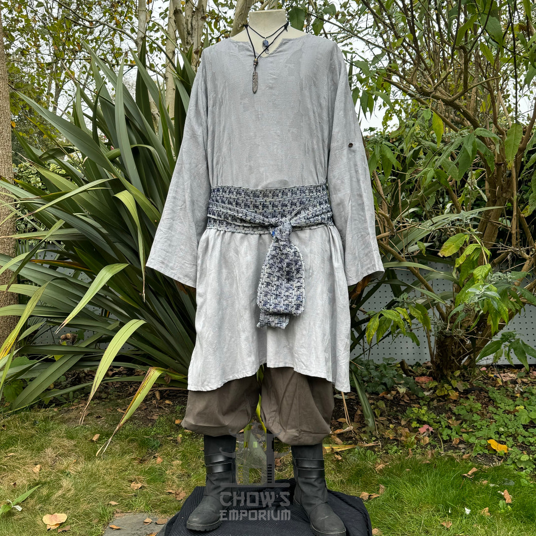 Elven Sage LARP outfit with grey tunic, patterned sash, and brown pants.