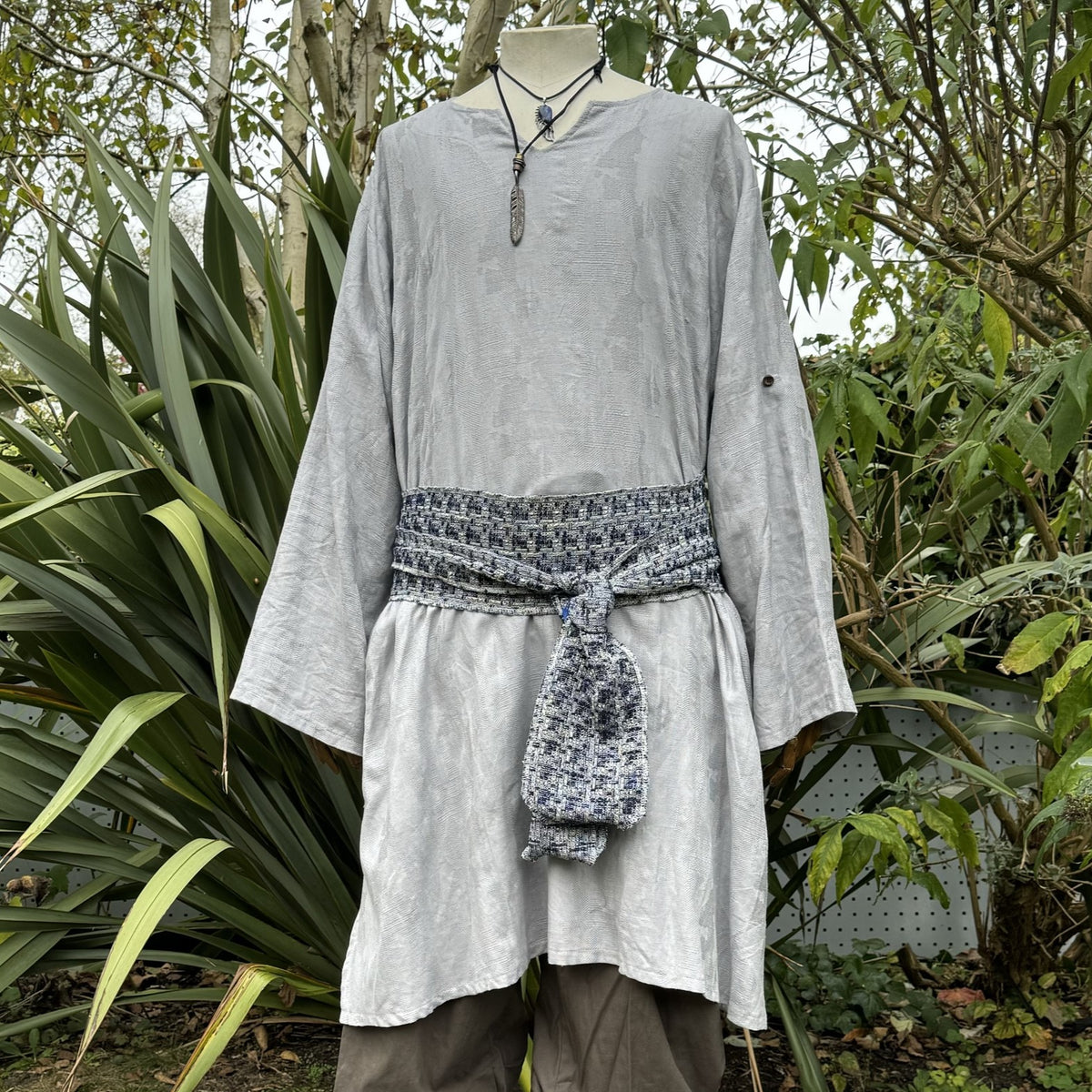 Grey medieval LARP tunic with patterned sash, front view.