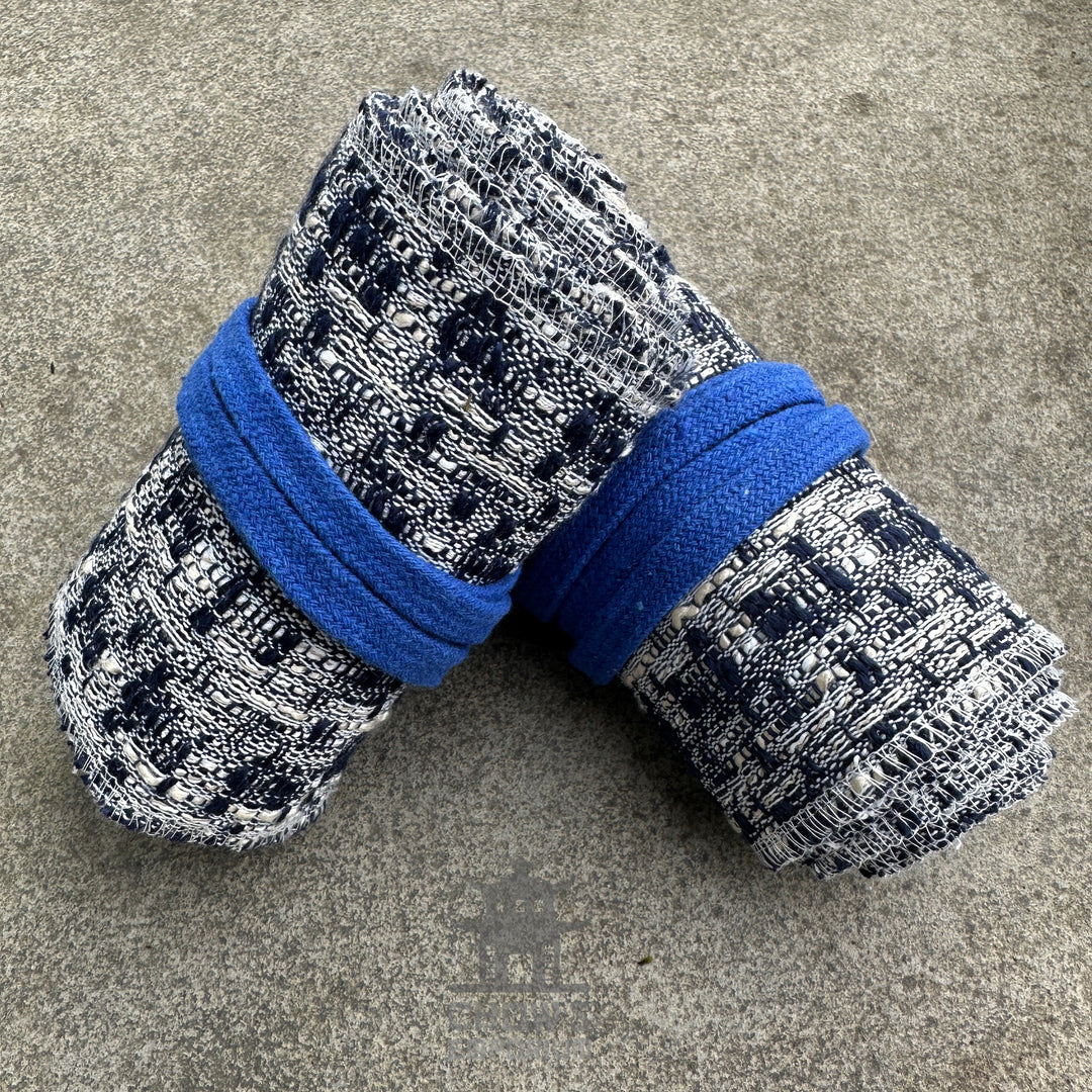 Blue and white knitted wool leg wraps, rolled side view, for medieval LARP.