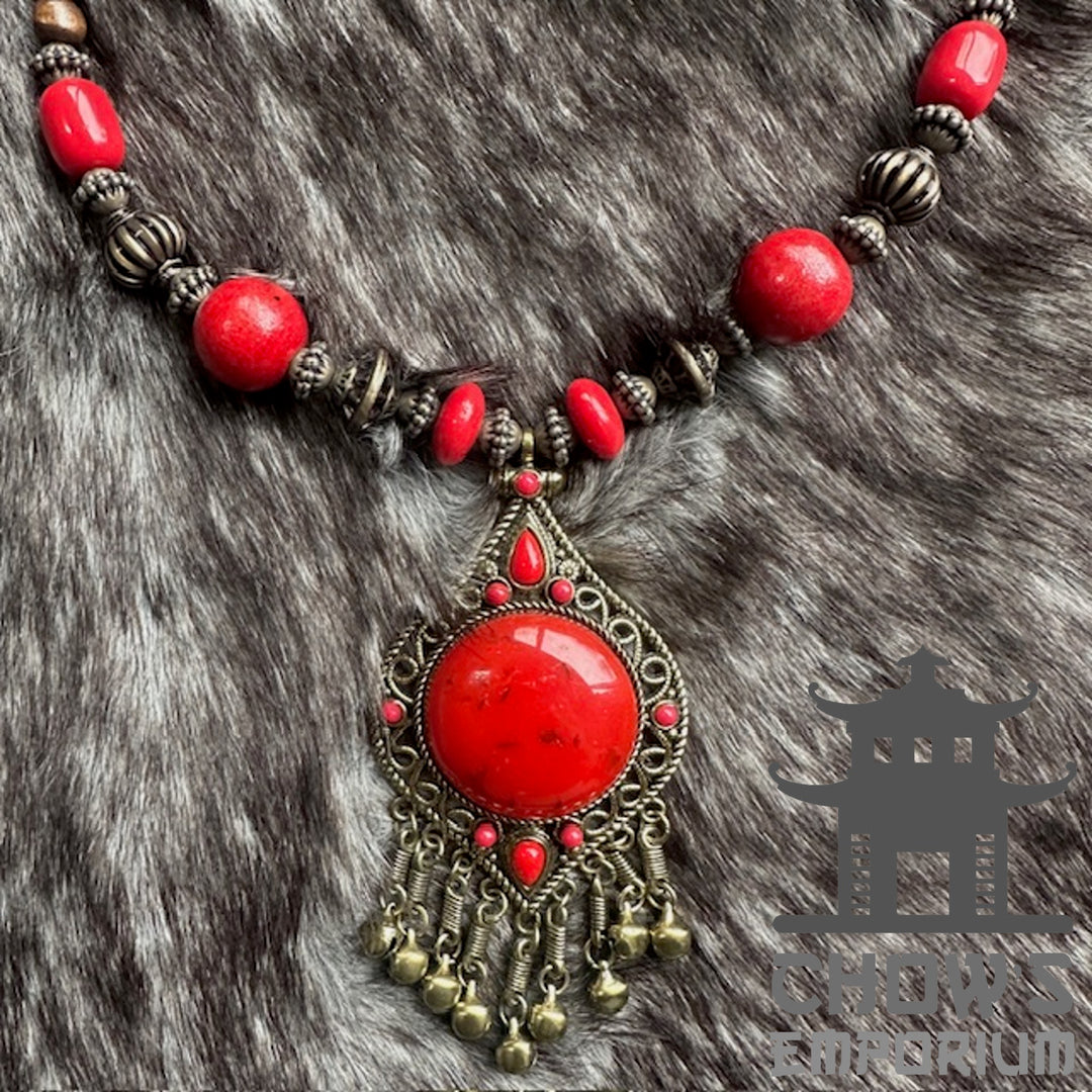 Red bohemian necklace with elaborate pendant for LARP on fur background.
