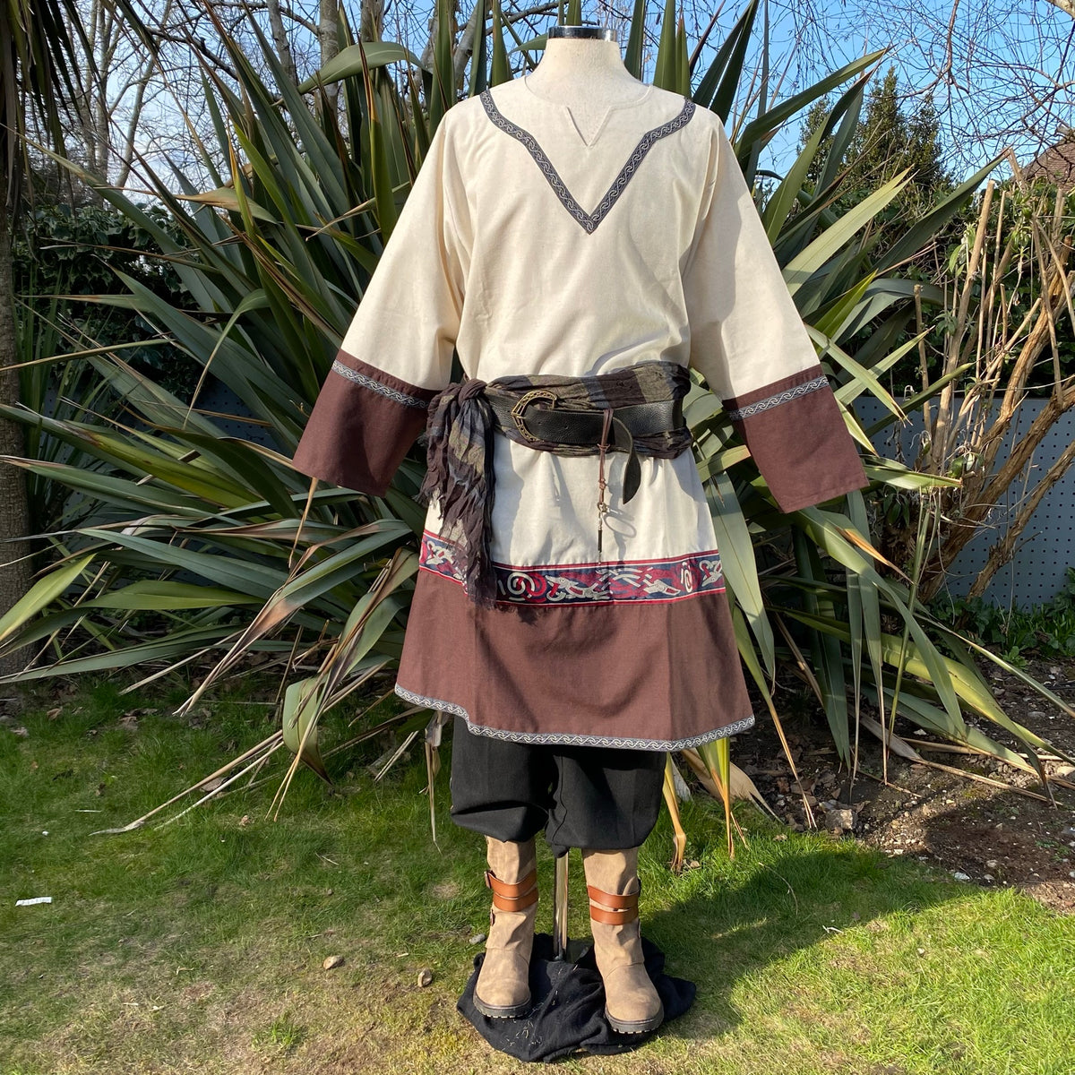Rear view of medieval tunic with belt and boots, set in a garden for LARP.