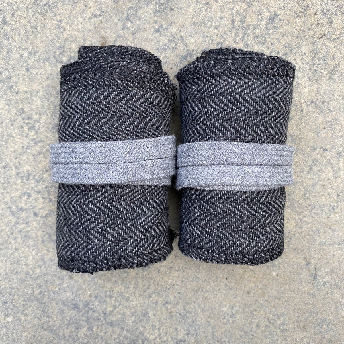 Two neatly rolled herringbone wool wraps for LARP.