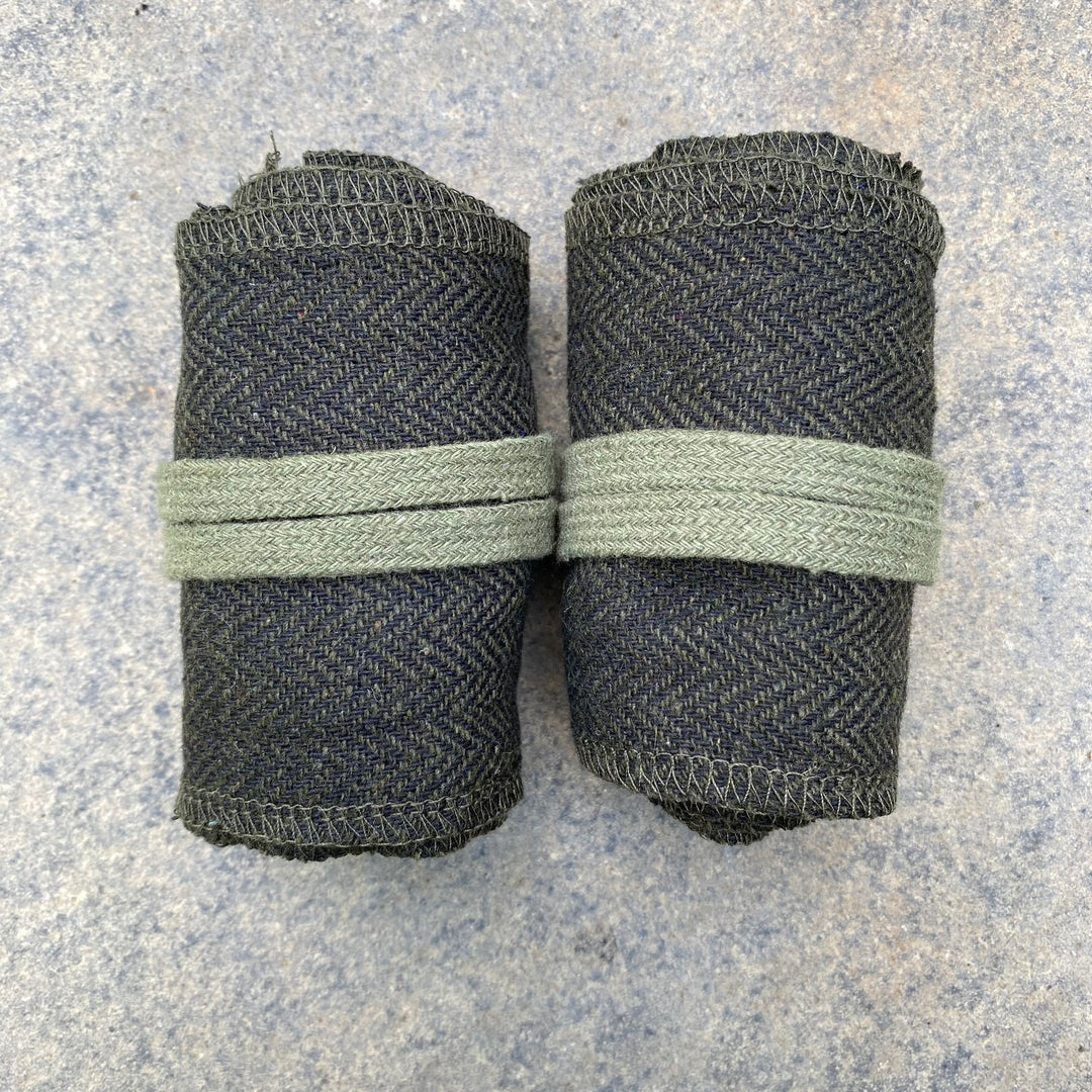 Green herringbone medieval wraps rolled up for LARP use, top view.