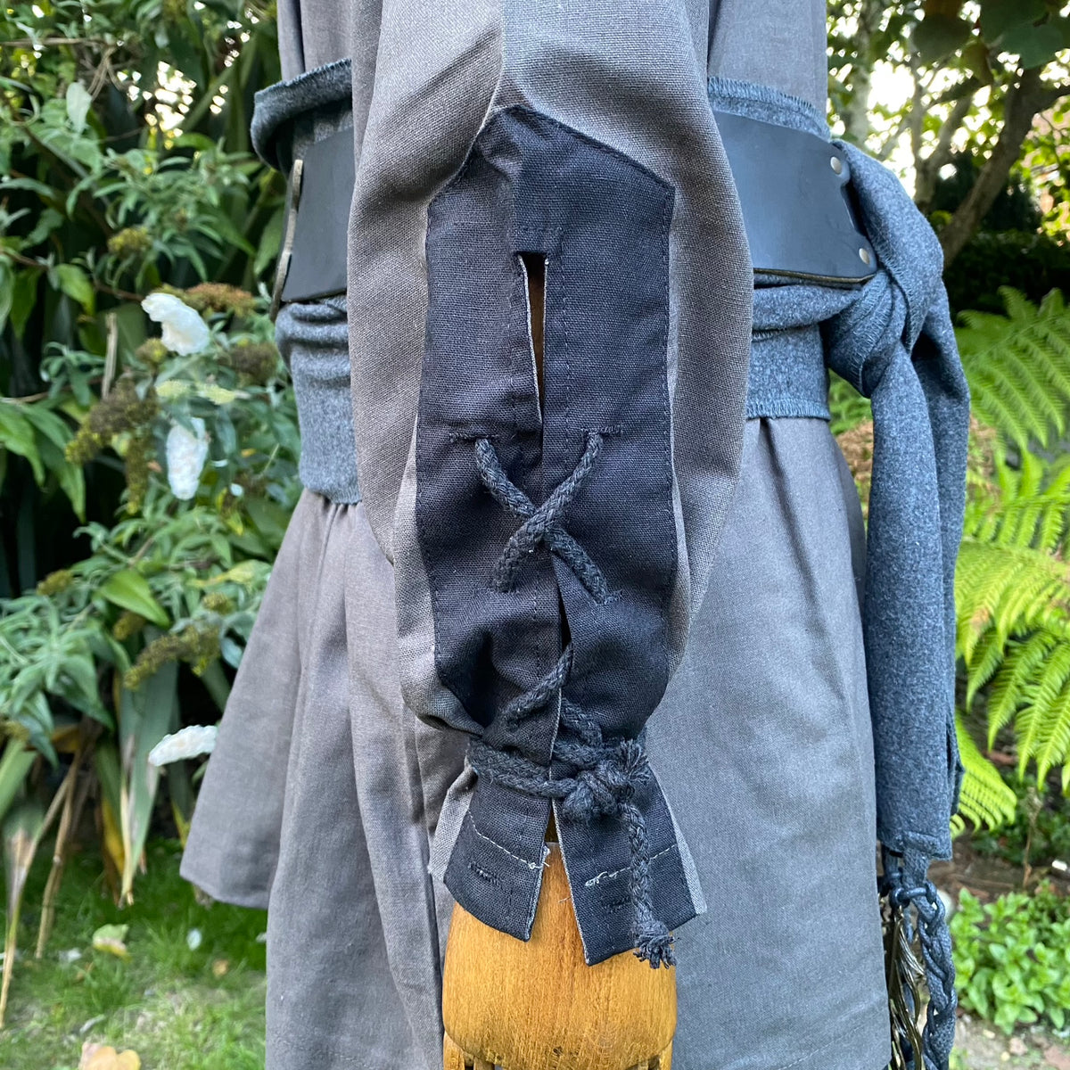 Grey LARP robe with black lace-up sleeve detail, close up.