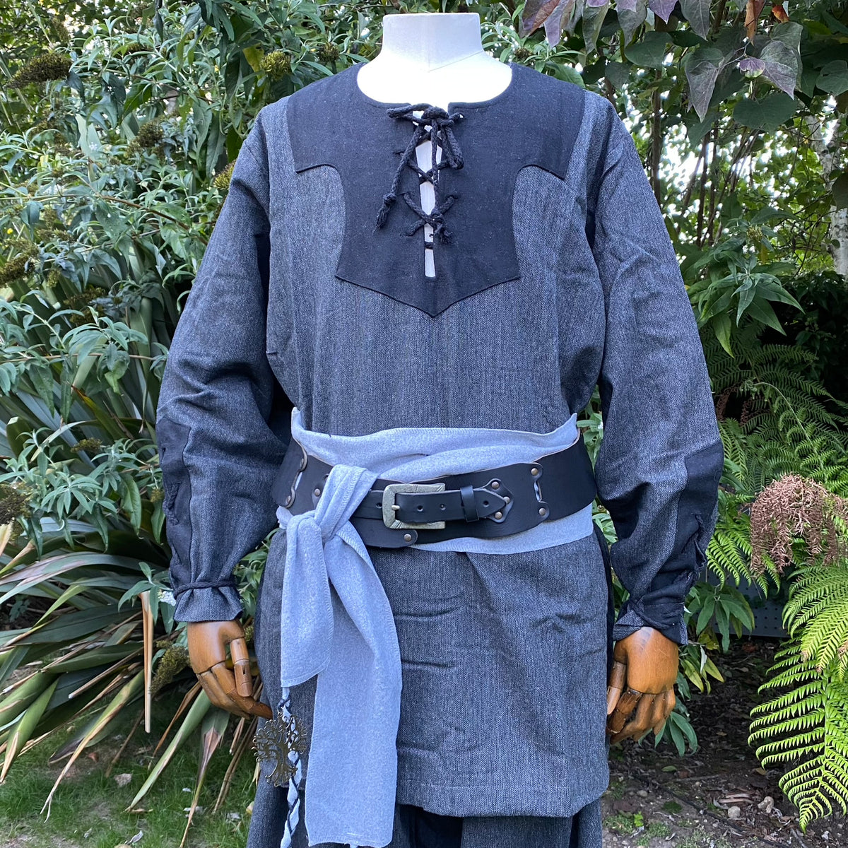 Medieval LARP outfit with laced shirt, grey sash, and buckle belt.