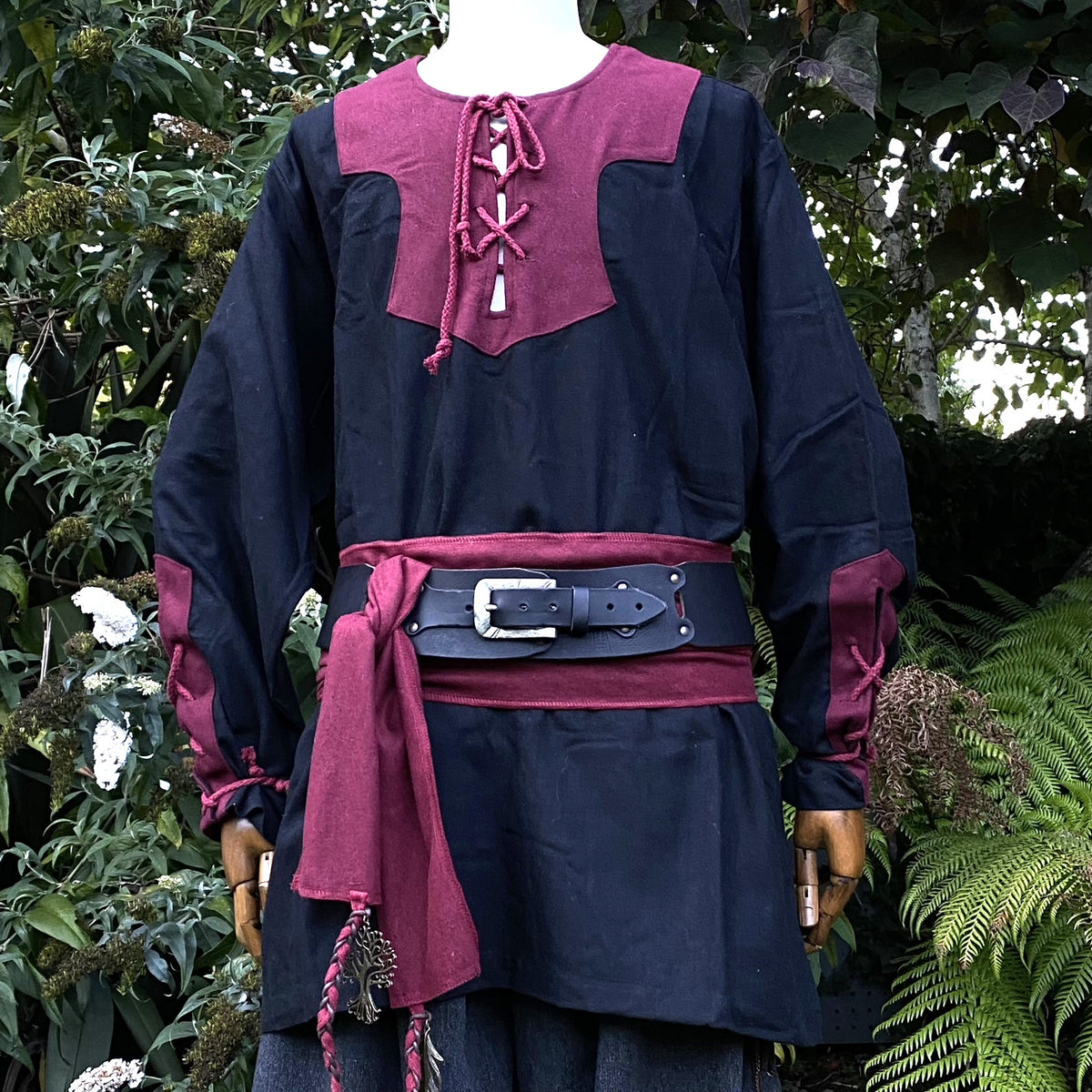 Medieval LARP attire: black tunic with red accents, sash tied.