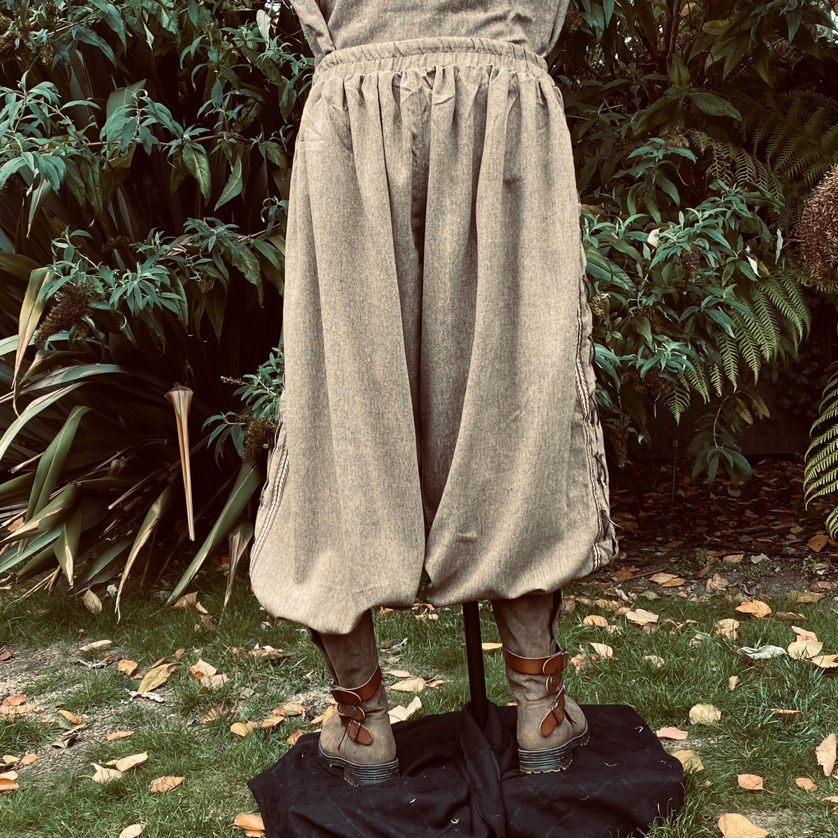 Back view of medieval LARP trousers, loose fit with leather-laced side detail.