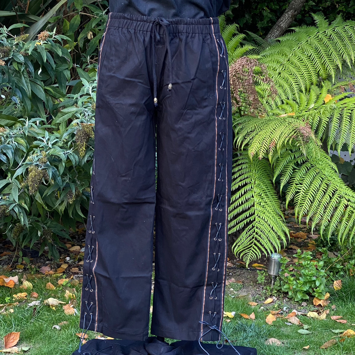 Black medieval trousers with lace side detail in garden setting LARP attire.