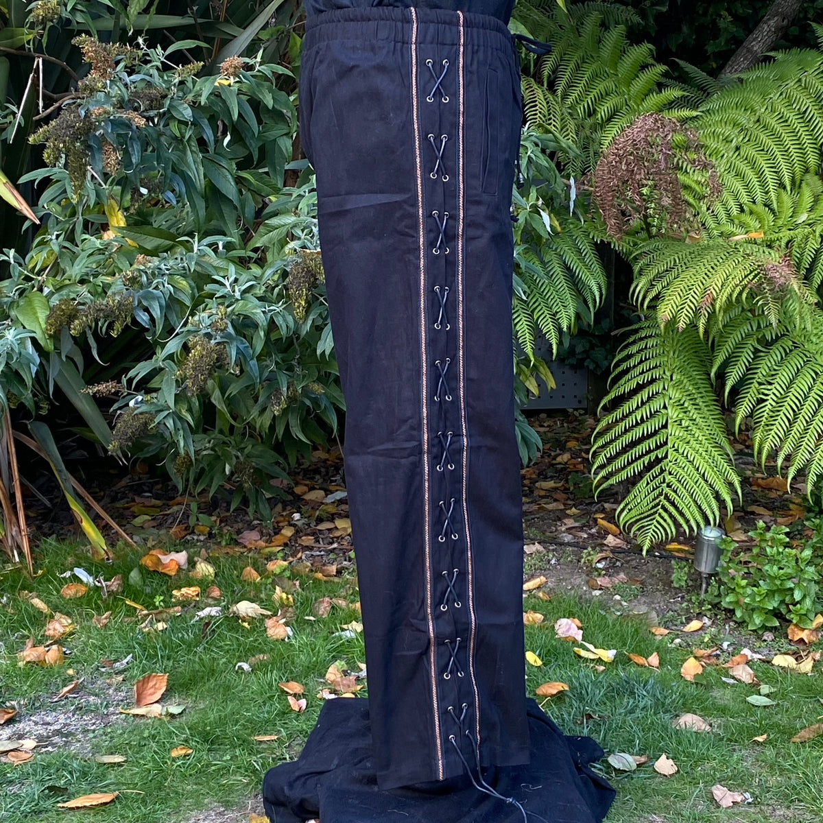 Side view of black medieval LARP trousers with lace detailing.