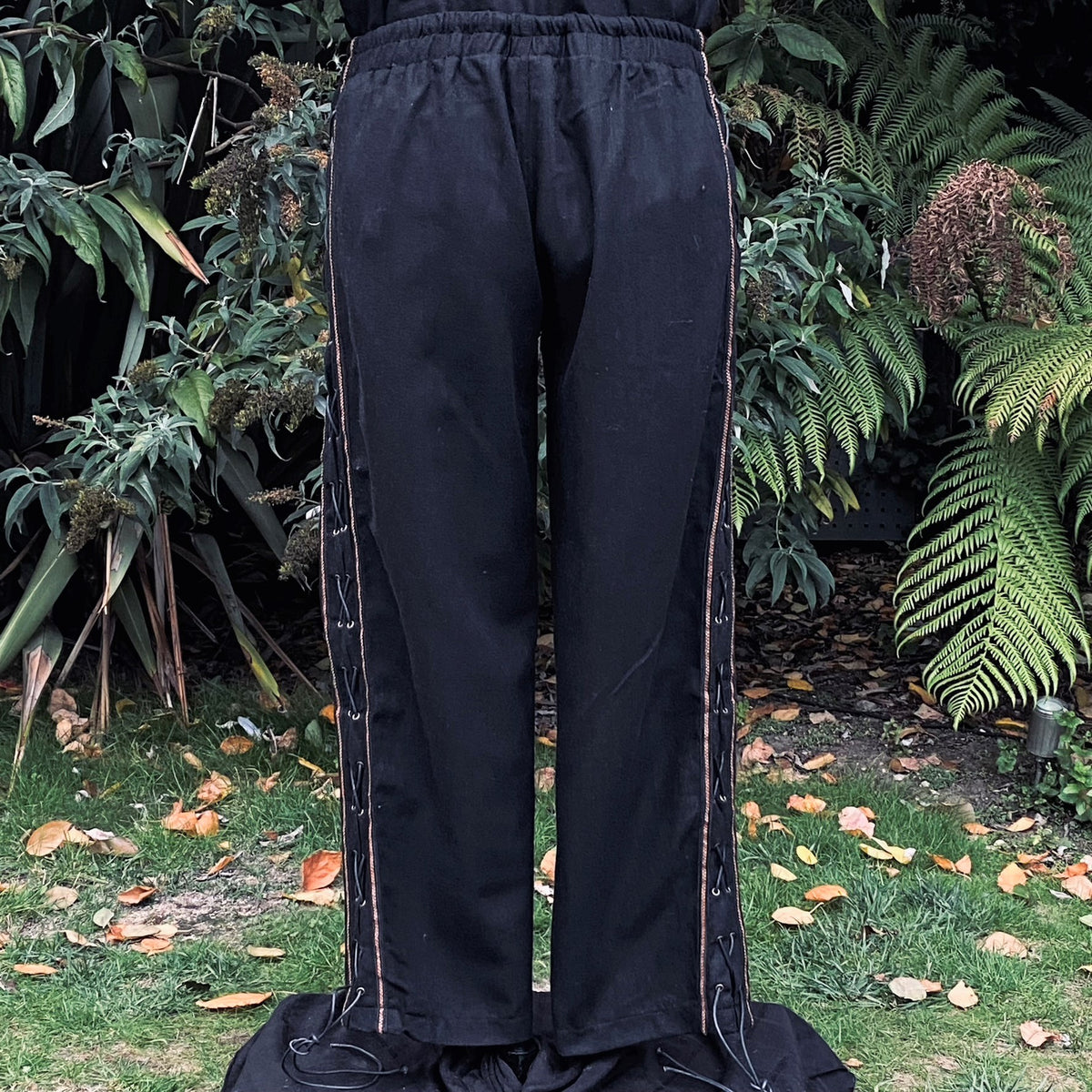 Black wool straight-leg LARP pants with side lace and braiding, front view.