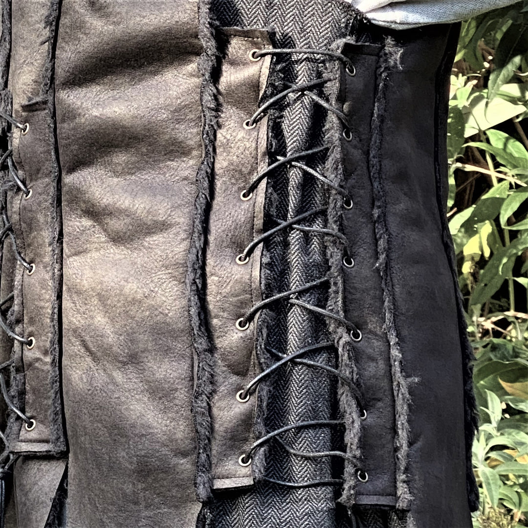 Dark medieval LARP waistcoat, close-up of textured black leather with lacing.