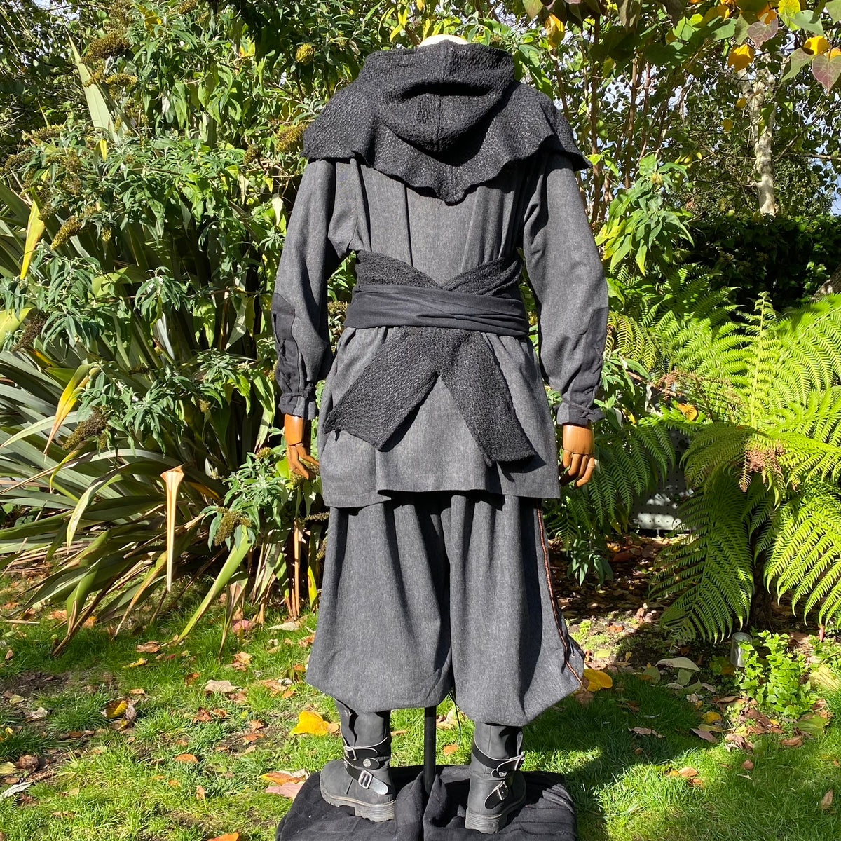 Back view of grey LARP outfit with hood, sash.