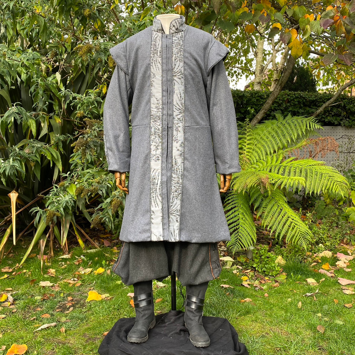 Grey medieval LARP coat with ornate trim.