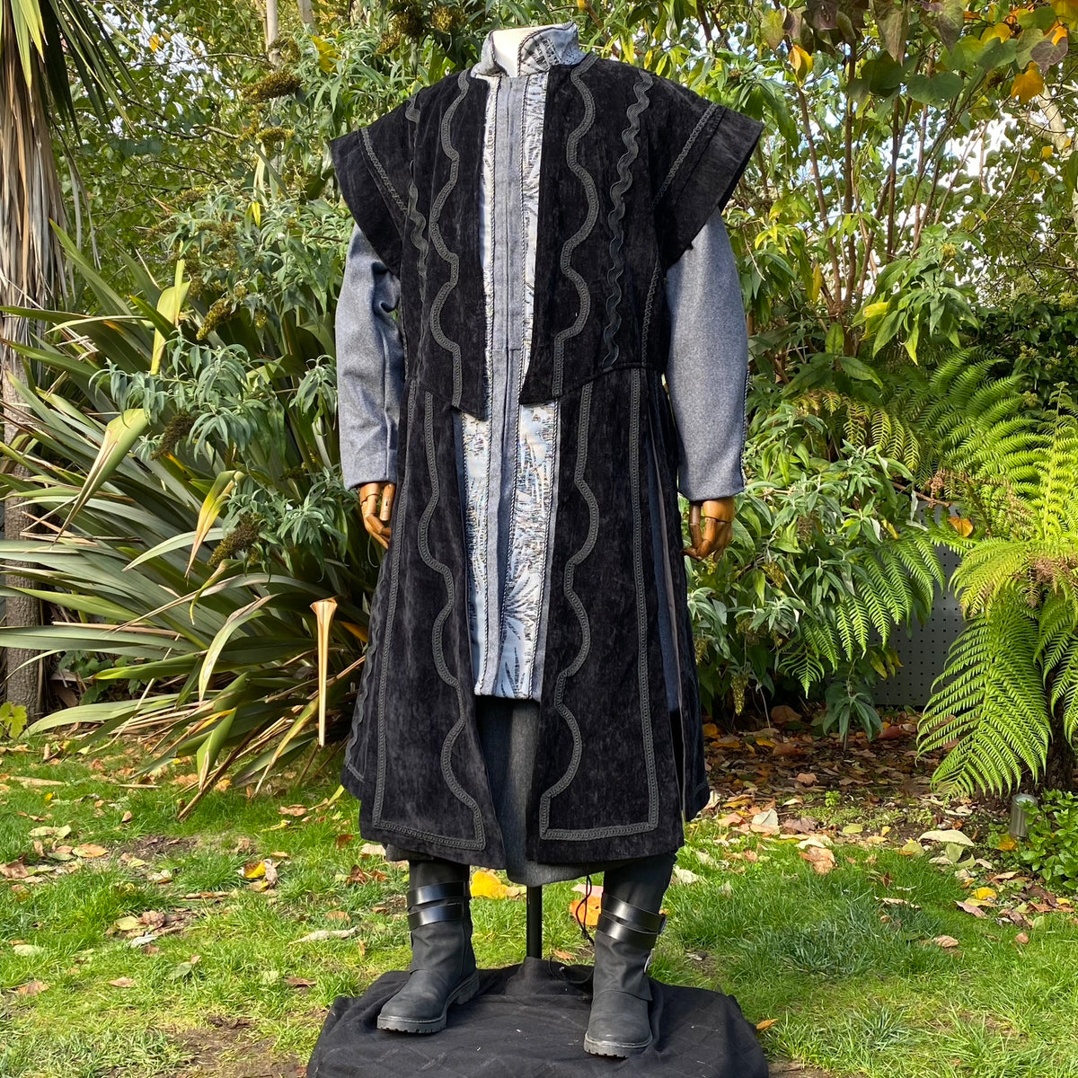 Mannequin in garden wearing medieval LARP outfit with ornate robe details.