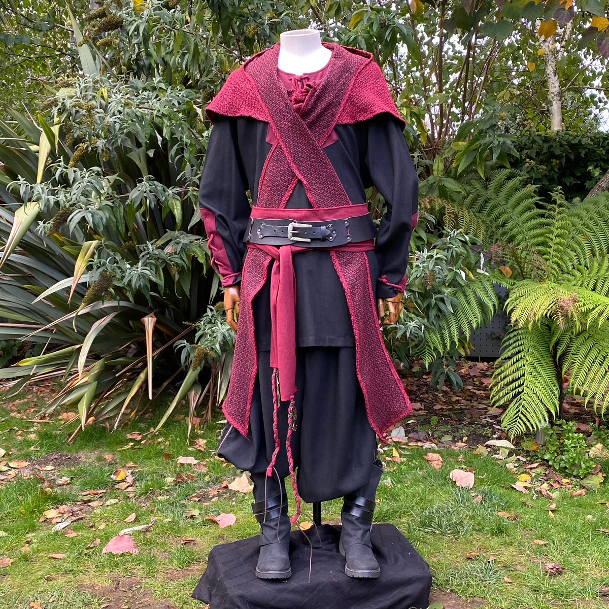 Red medieval wool hood, draped over a black tunic with belt, LARP style.