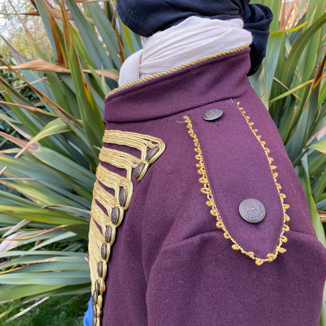 Maroon pirate coat with gold trim detail, side garden view, for LARP events.