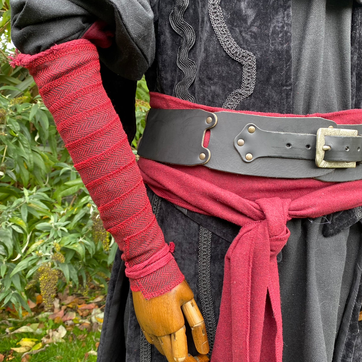 Red herringbone arm wrap, medieval belt with black tunic for LARP.