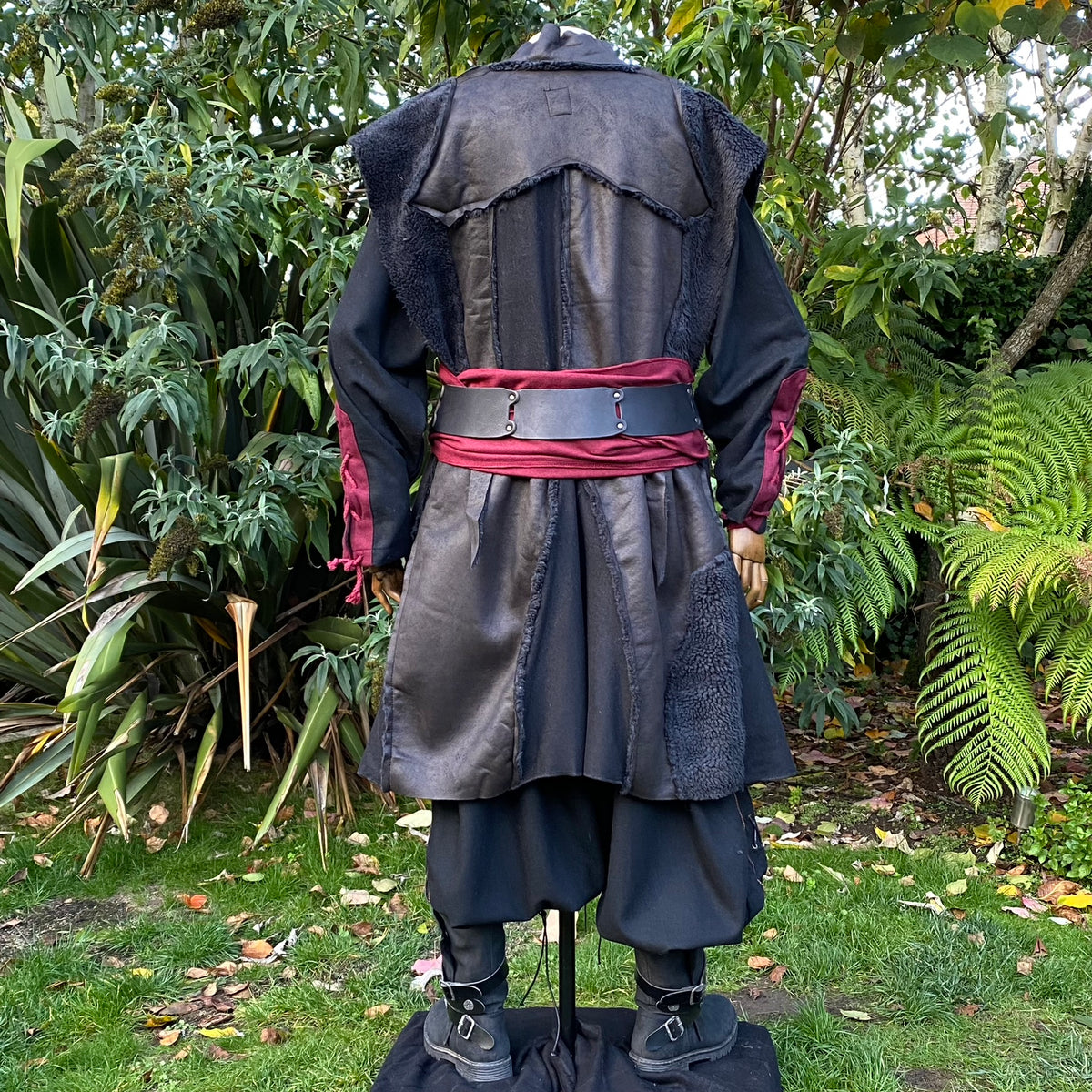 Back view of black faux leather medieval waistcoat, burgundy accents, LARP setting.