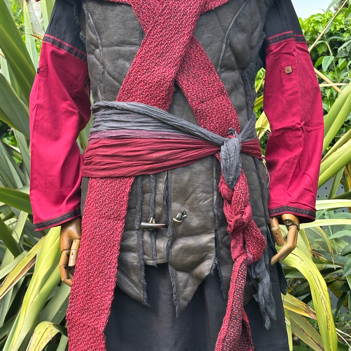 Black and red medieval LARP outfit with shirt, pants, sash, and hood.