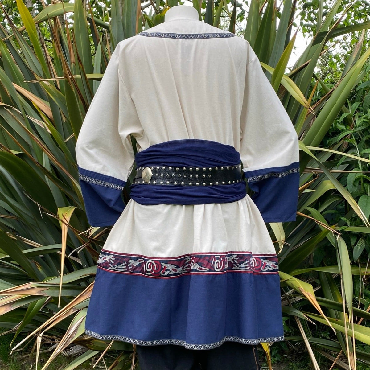 Rear view LARP tunic in white and blue, black studded belt.