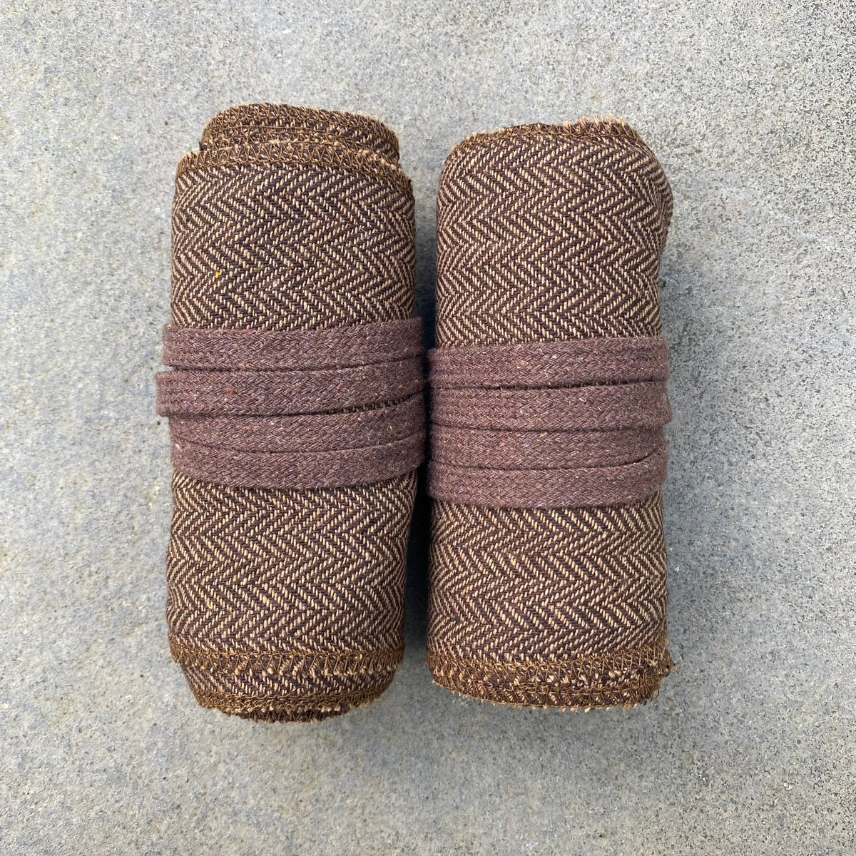 Brown herringbone leg wrap puttees rolled for medieval LARP events.