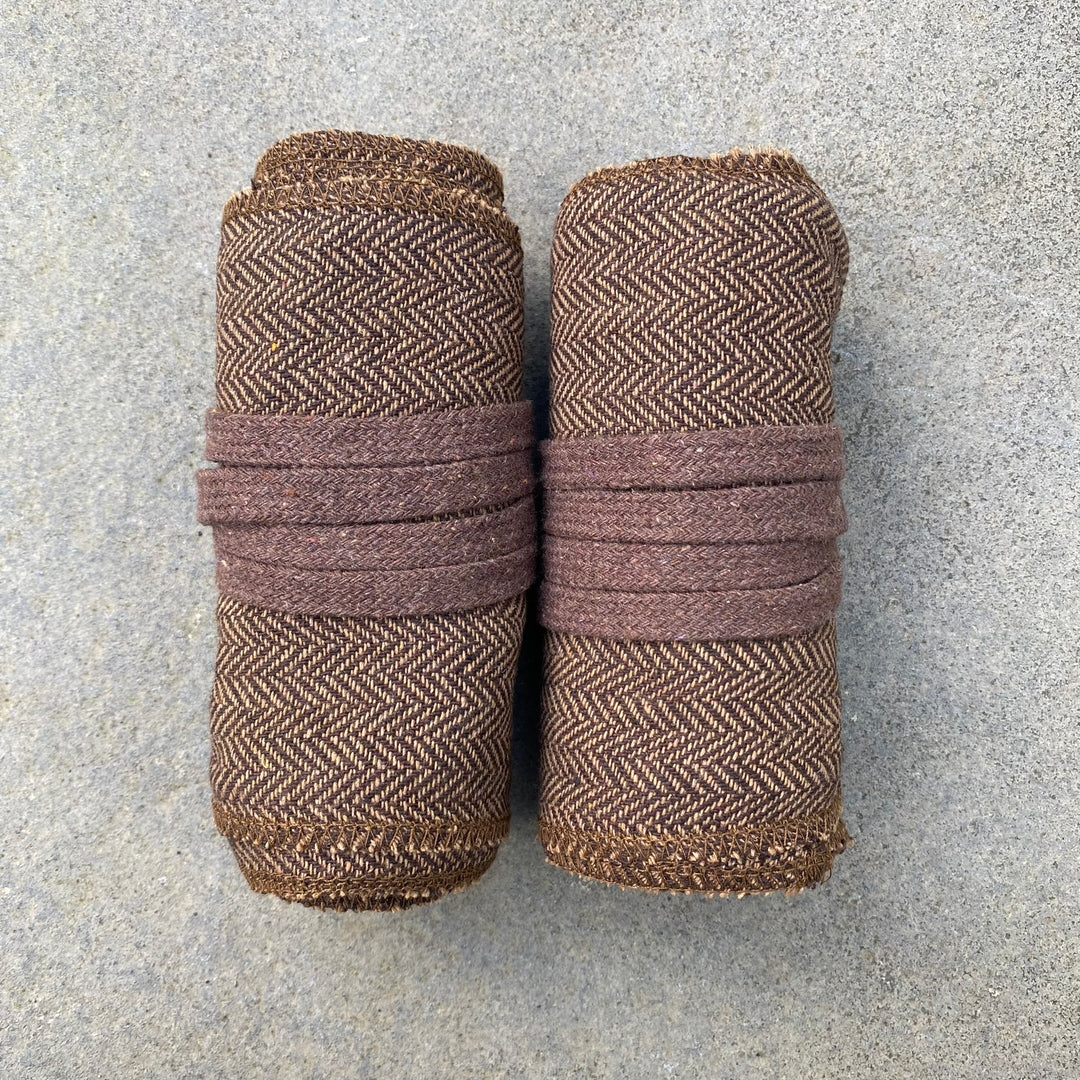 Brown herringbone leg wrap puttees rolled for medieval LARP events.
