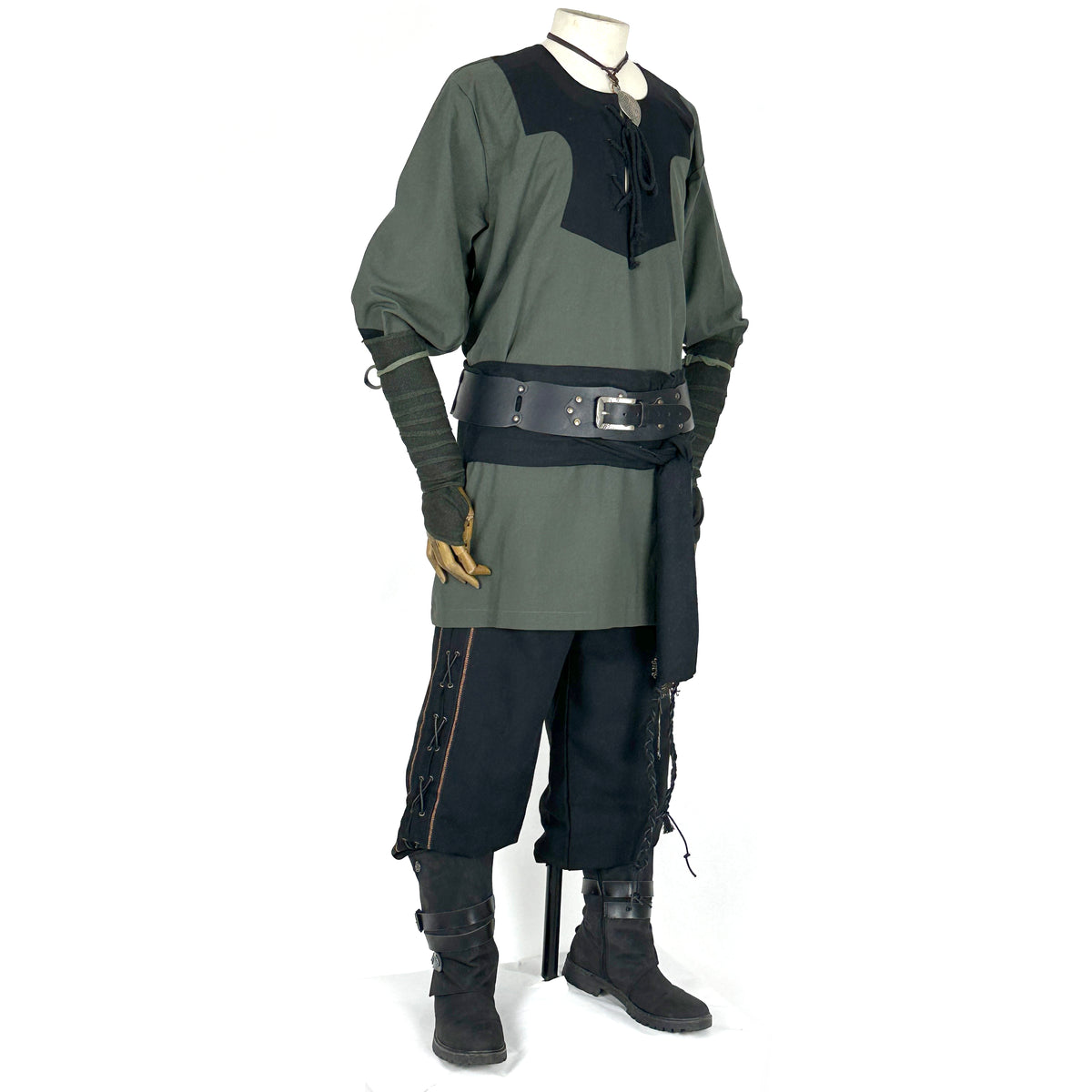 Medieval LARP outfit side view, featuring a green and black viking tunic, arm wraps, trousers.