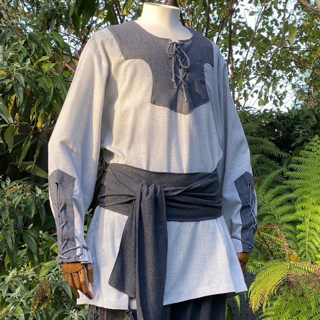 Grey medieval LARP tunic close-up with dark sash.